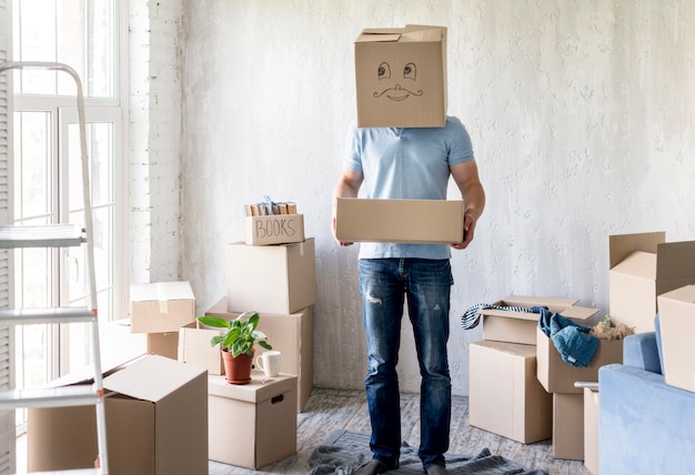 Man met doos boven het hoofd tijdens het inpakken om te verhuizen