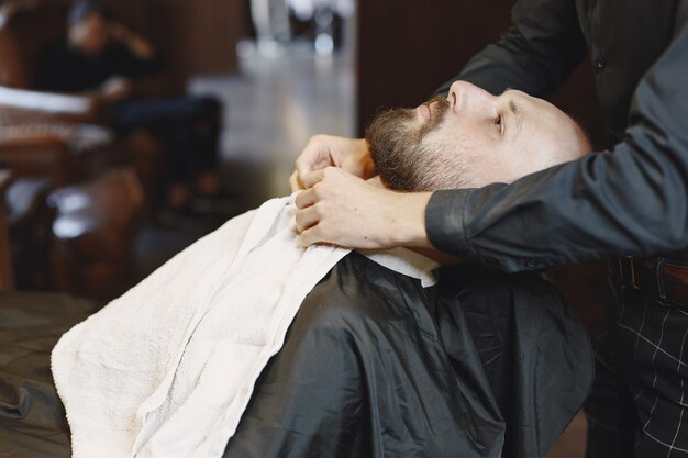 Man met een baard. Kapper met een klant. Man met een penseel.