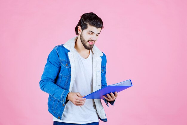 Man met een blauwe map en ziet er positief uit