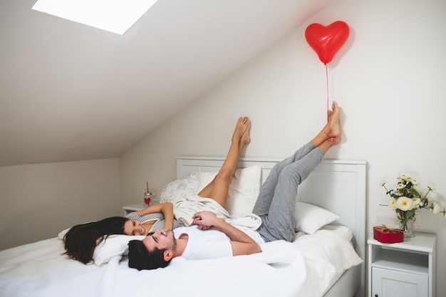 Gratis foto man met een hartvormige ballon met zijn voeten