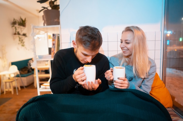 Man met een jonge vrouw die hete koffie en thee drinkt