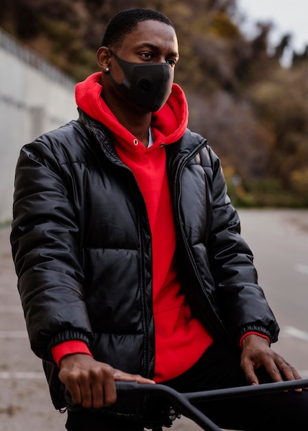 Man met een masker en met zijn fiets