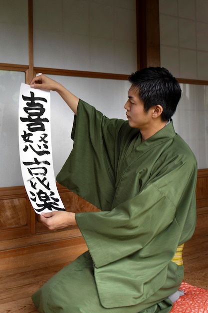 Gratis foto man met een papier met japans handschrift