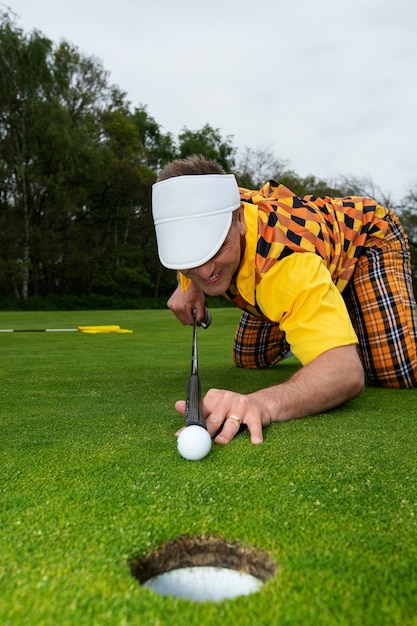 Man met een partijtje golf buiten op de baan