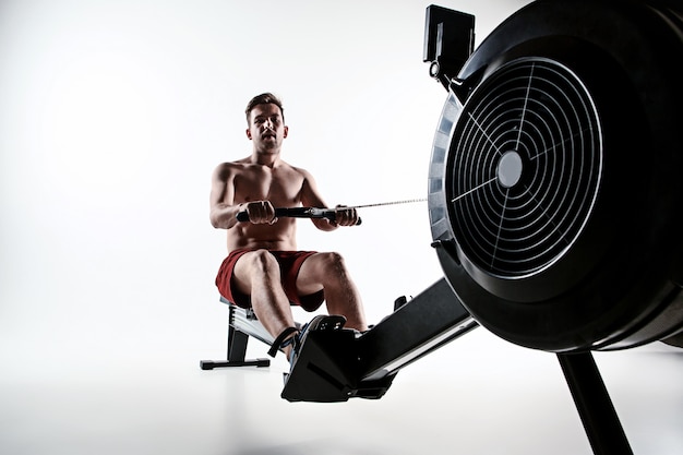 Man met een persmachine in een fitnessclub.