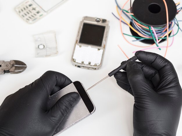 Man met een schroevendraaier om een telefoon te openen