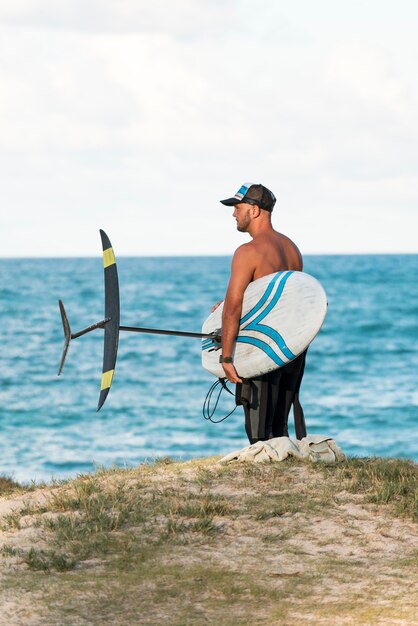 Man met een surfplank buitenshuis