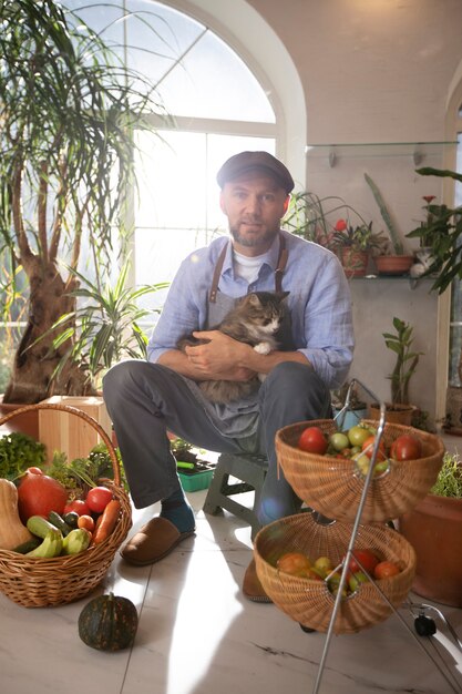Man met groenten die binnenshuis zijn verbouwd en gekweekt