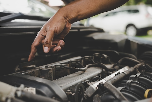 Man met het controleren van auto-motor.