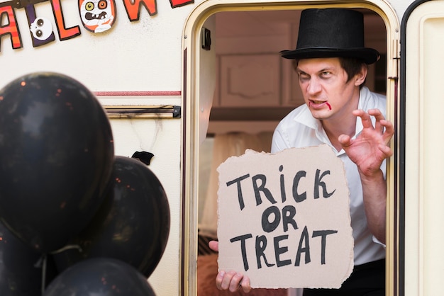 Man met hoed met trick or treat-teken