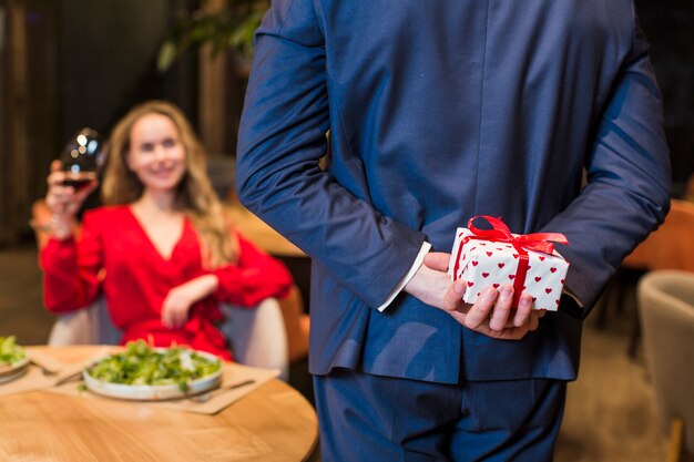 Man met kleine geschenkdoos achter rug