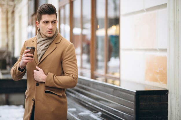 Man met koffie buiten in de winter