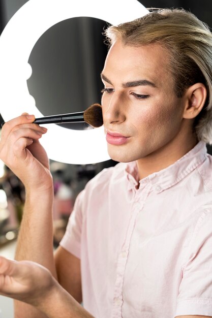 Man met make-up en naar beneden te kijken