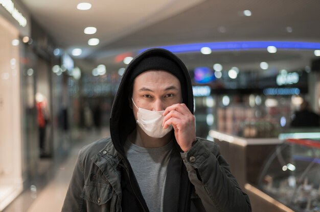 Man met medisch masker in het winkelcentrum