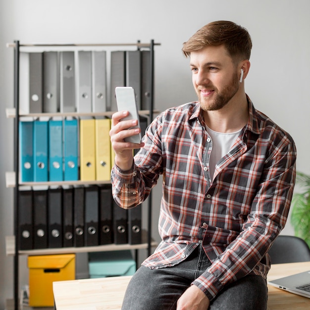 Gratis foto man met mobiel en airpods