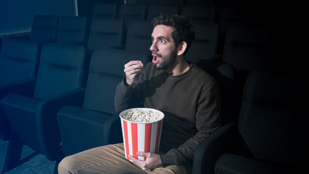 Man met popcorn in de bioscoop