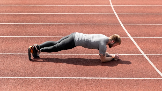 Man met prothetisch been die plank volledig schot doet