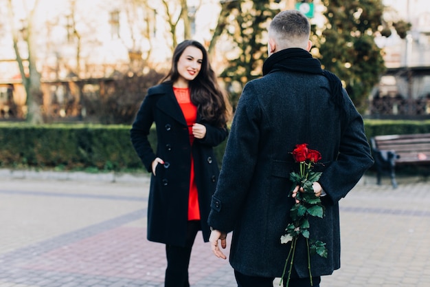 Man met rozen voor elegante vriendin