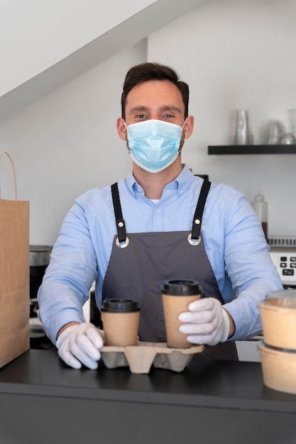 Man met schort eten klaarmaken voor afhaalmaaltijden