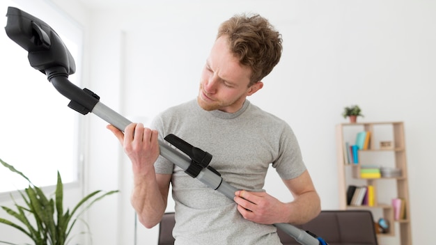 Man met stofzuigen huis