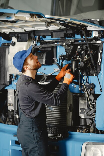 Man met tools voor vrachtwagen. Werknemer in uniform. Defecte truck