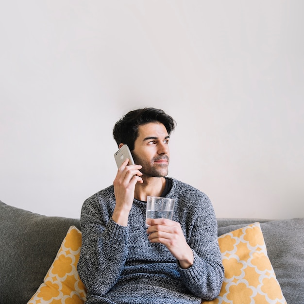 Man met water spreken op telefoon