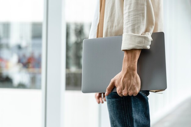 Man met zijn laptop tijdens het wandelen in de stad