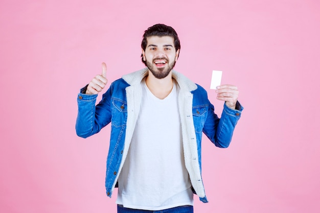 Man met zijn visitekaartje en duim opdagen