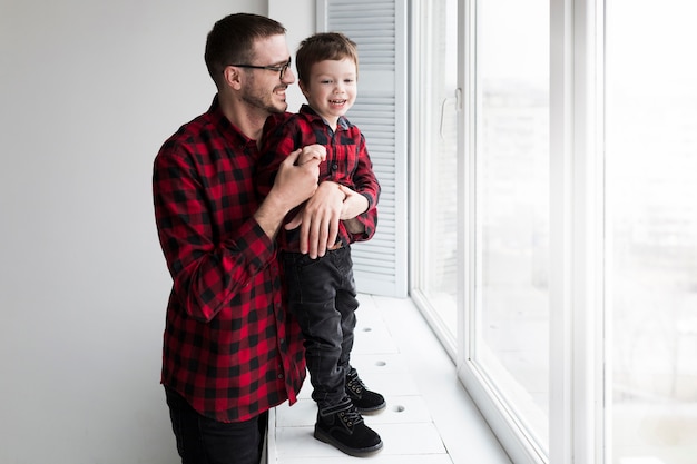 Gratis foto man met zoon op vaders dag voor schoolbord