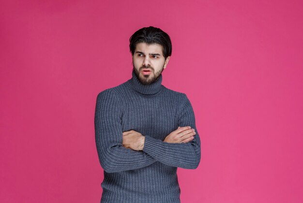 Man met zwarte baard ziet er uitgeput en verveeld uit.