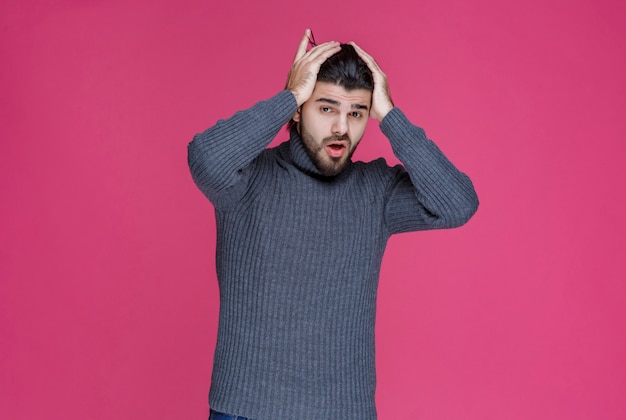 Man met zwarte baard ziet er uitgeput en verveeld uit.