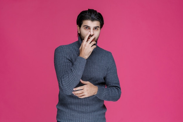 Man met zwarte baard ziet er uitgeput en verveeld uit.