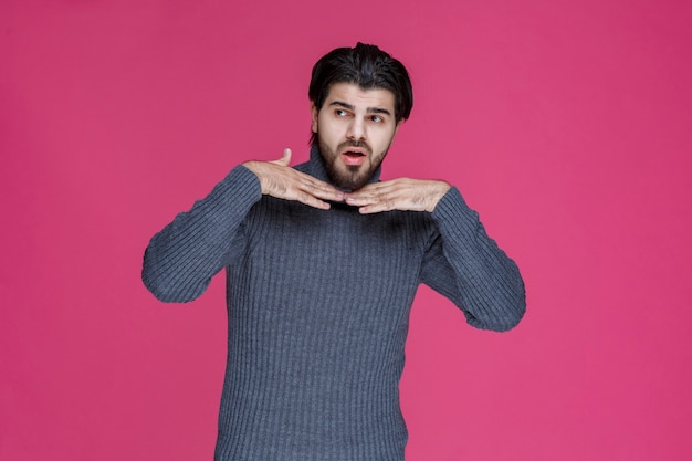 Man met zwarte baard ziet er uitgeput en verveeld uit.