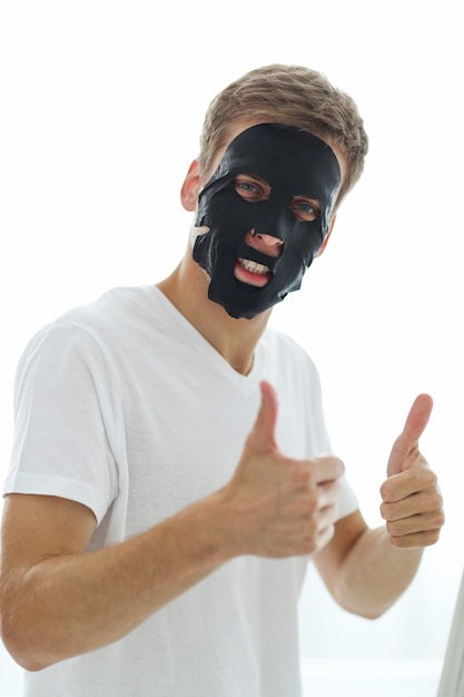 Man met zwarte gezichtsmasker, huid zuiverende houtskool. schoonheid concept