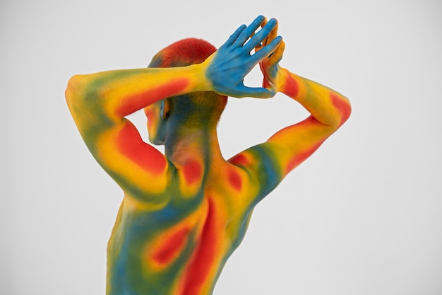 Gratis foto man model poseren met kleurrijke bodypainting