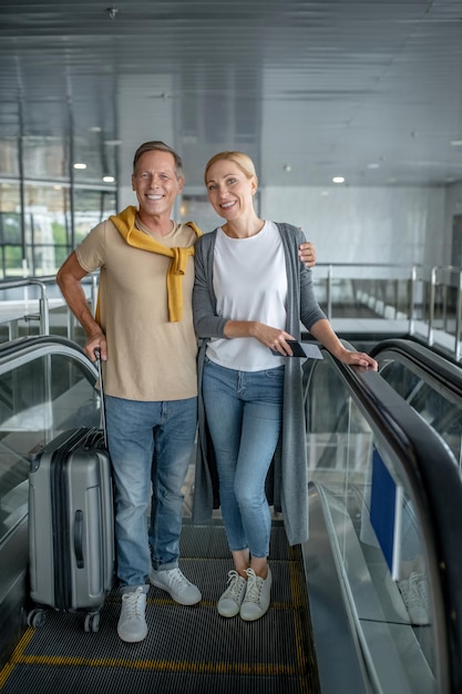 Man omhelst een vrouw met het kaartje op de roltrap