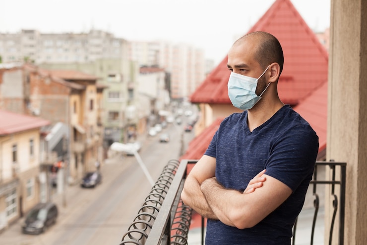 Gratis Foto man ontspannen op balkon tijdens uitbraak van coronavirus.
