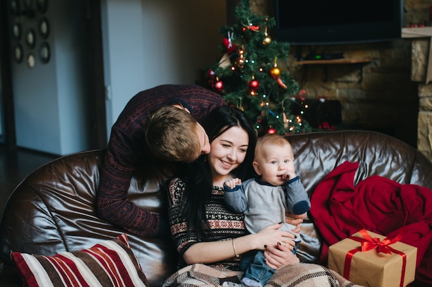 Gratis foto man op zoek naar zijn vrouw terwijl ze houdt haar baby in haar armen