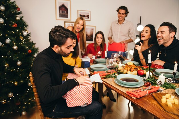 Man opening aanwezig bij kerstdiner