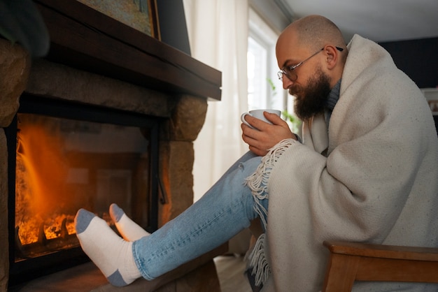 Gratis foto man opwarming bij open haard tijdens energiecrisis