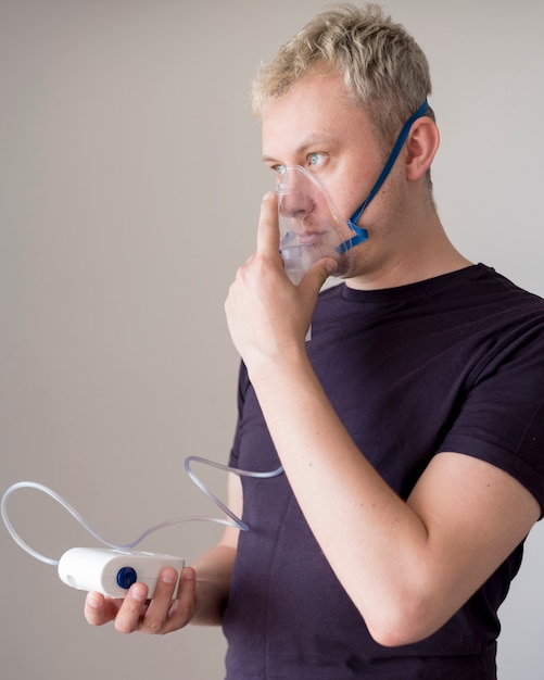 Gratis foto man permanent en met behulp van een zuurstofmasker