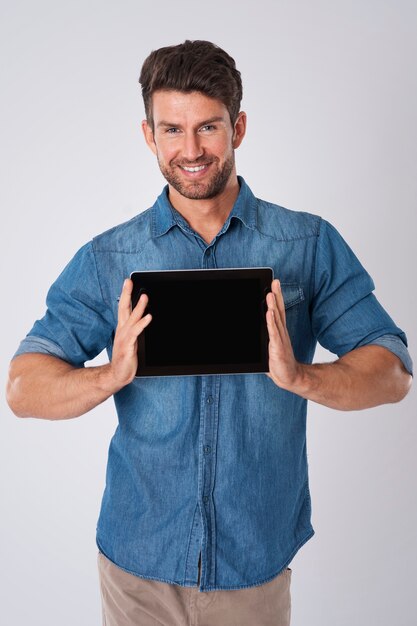 man poseren met denim overhemd en tablet