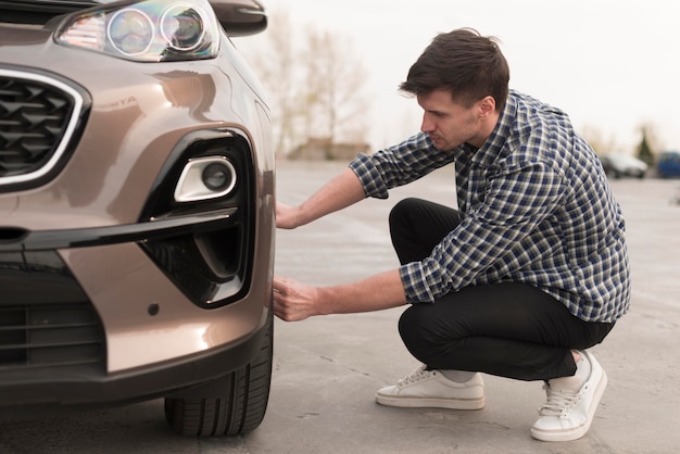 Man probeert auto wiel te vervangen