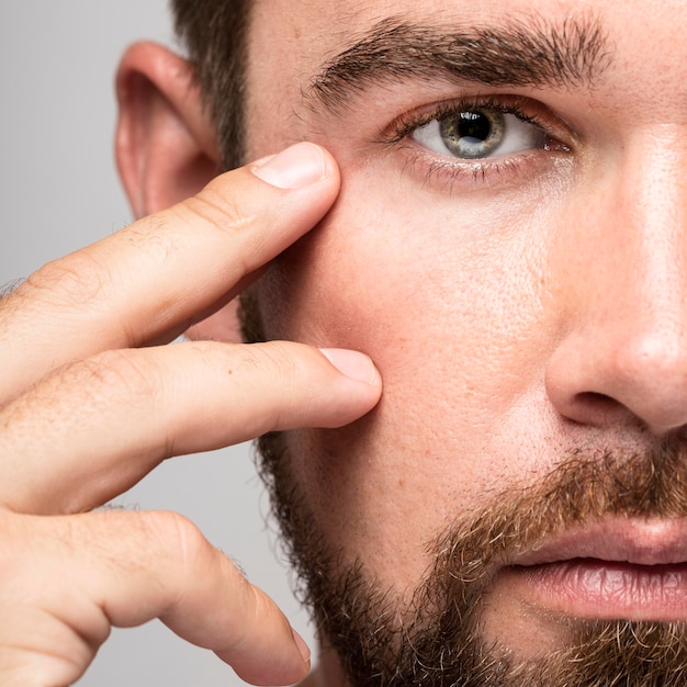 Man raakt zijn gezicht close-up aan