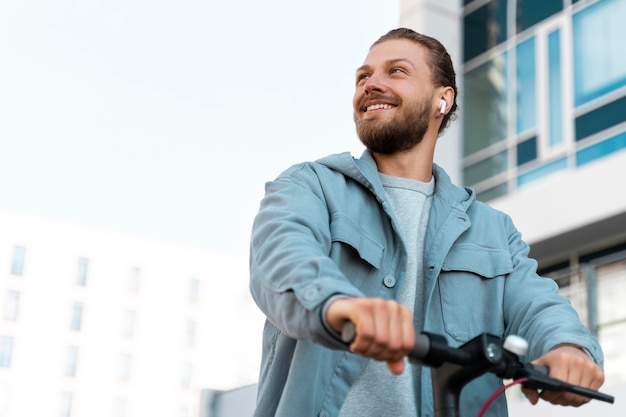 Gratis foto man rijdt op een milieuvriendelijke scooter