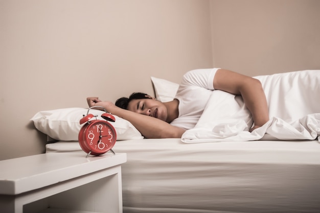 Man slaap in bed met rood alarm op de voorgrond