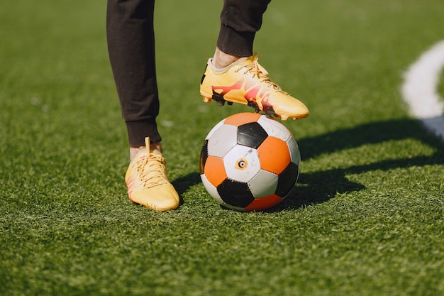 Man speelt socerl in het park. Toernooi op mini-footbal. Kerel in zwarte sportpakken.