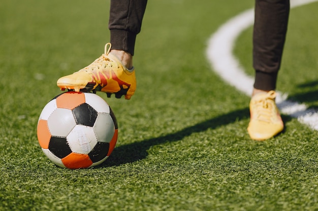 Gratis foto man speelt socerl in het park. toernooi op mini-footbal. kerel in zwarte sportpakken.