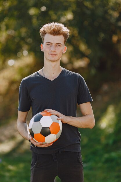 Man speelt socerl in het park. Toernooi op mini-footbal. Kerel in zwarte sportpakken.