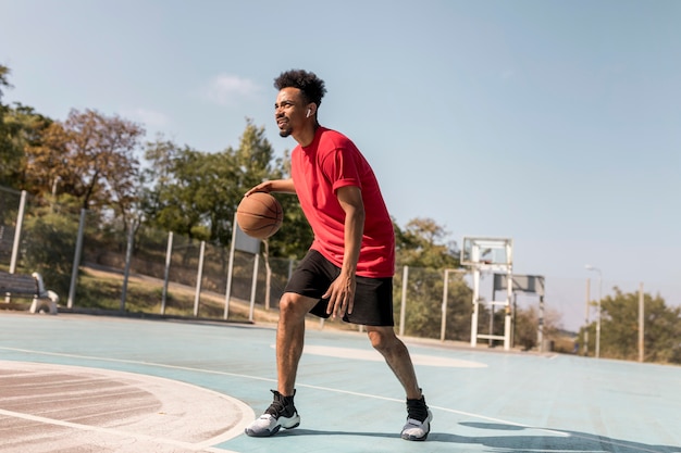 Man spelen basketbal buitenshuis